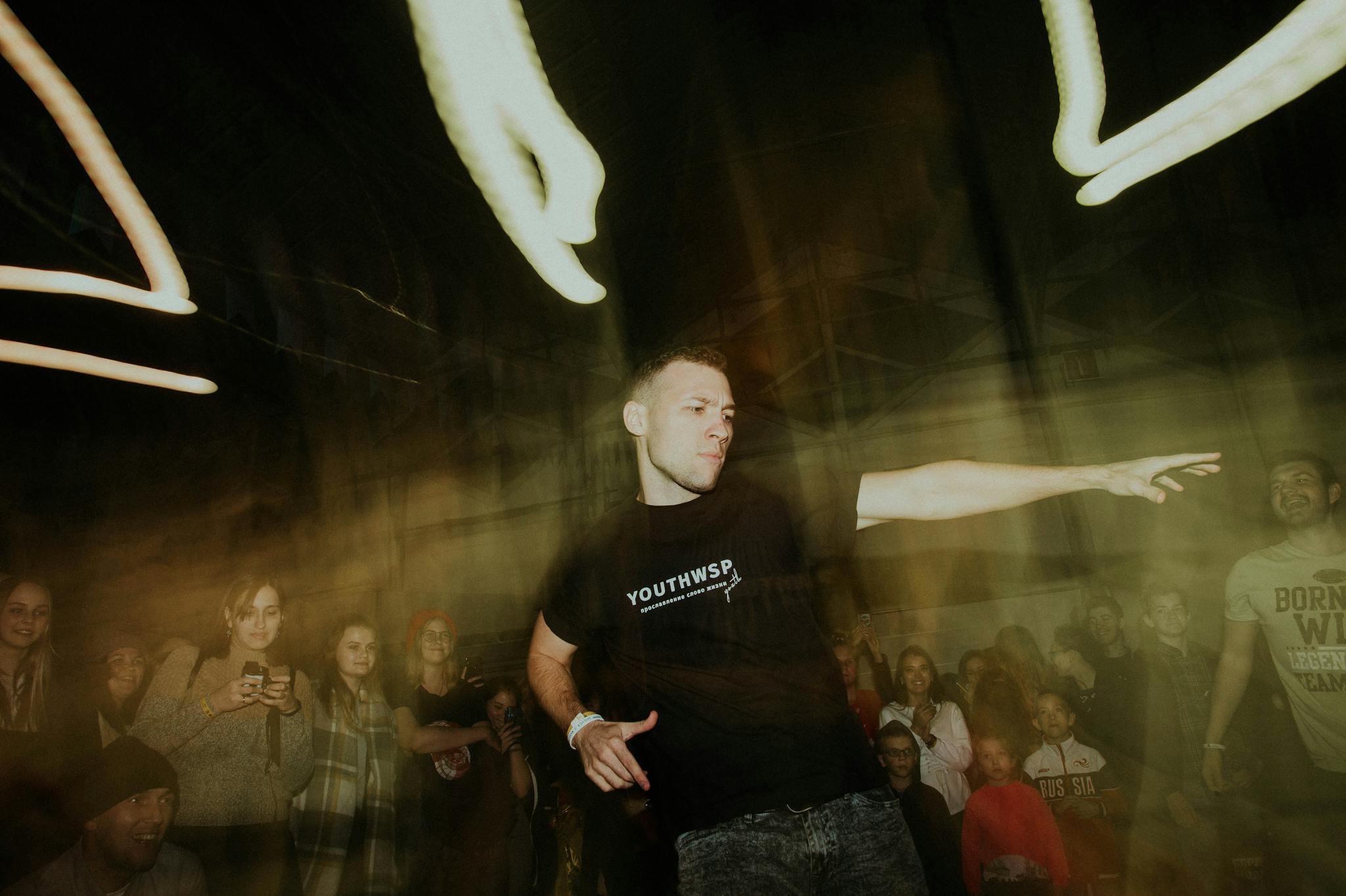 A dynamic scene of a dancer performing at a lively night party with a crowd gathered around.