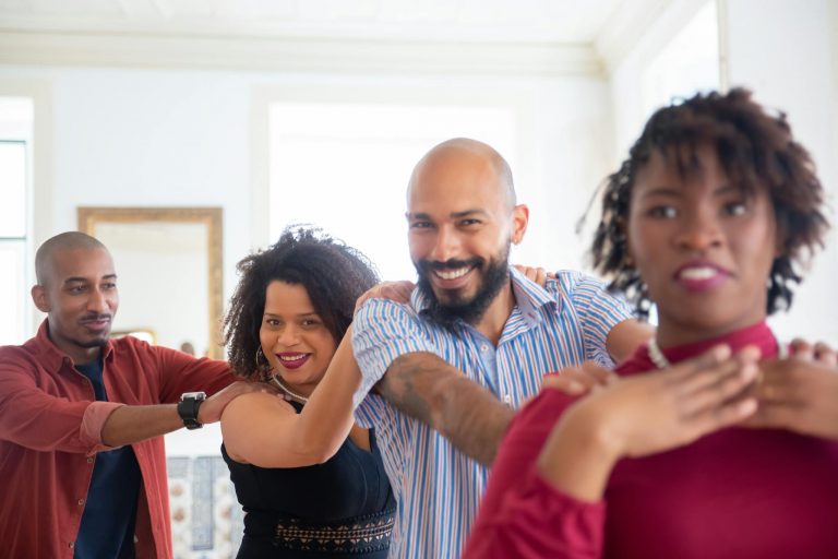A happy group of friends dancing indoors, celebrating friendship with joy and smiles.