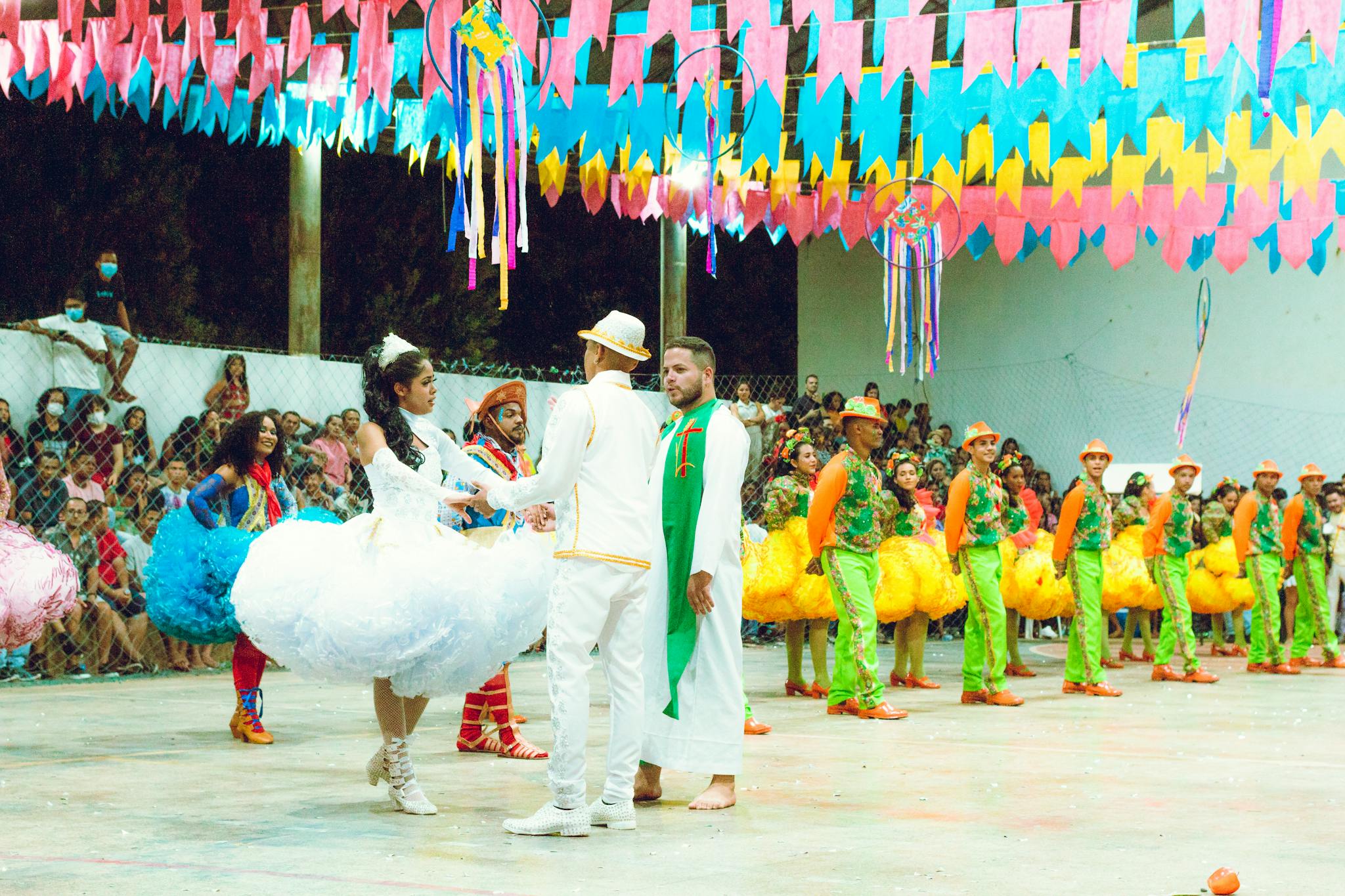 Colorful dancers in traditional attire performing at a lively night festival.