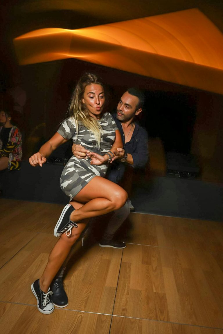 Dynamic image of a couple dancing energetically in a modern dance club setting.